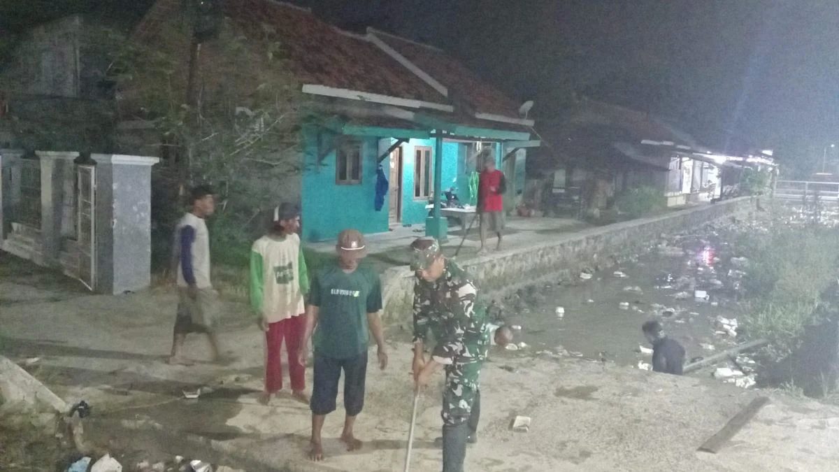 Babinsa & Warga Bersihkan Irigasi Malam Hari